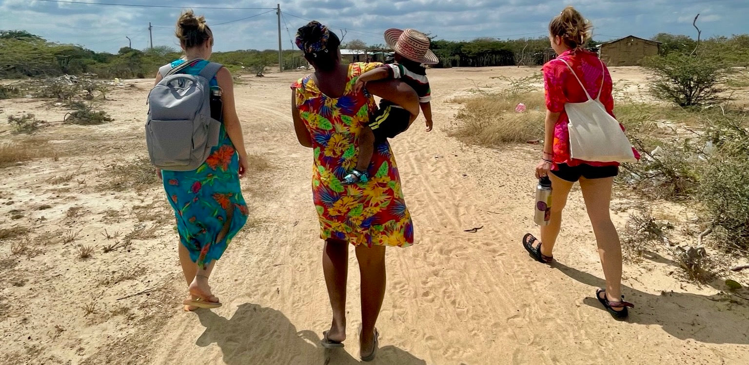 women walking through a traditional Wayuu community