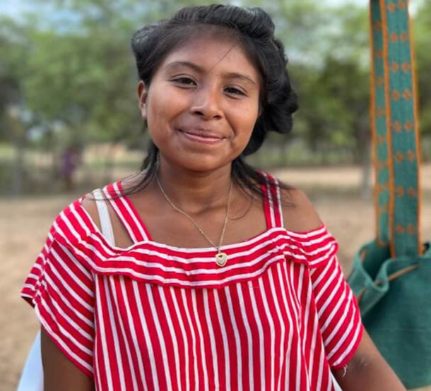 Wayuu women in front of a crossbody crochet mochila bag