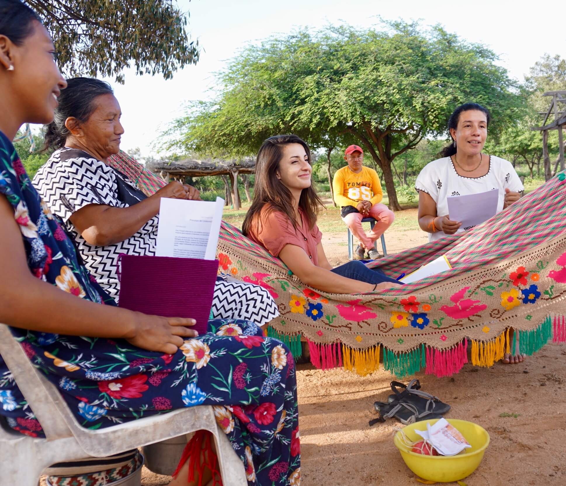 young woman in a Wayuu chinchorro surrounded by other women in an Indigenous village