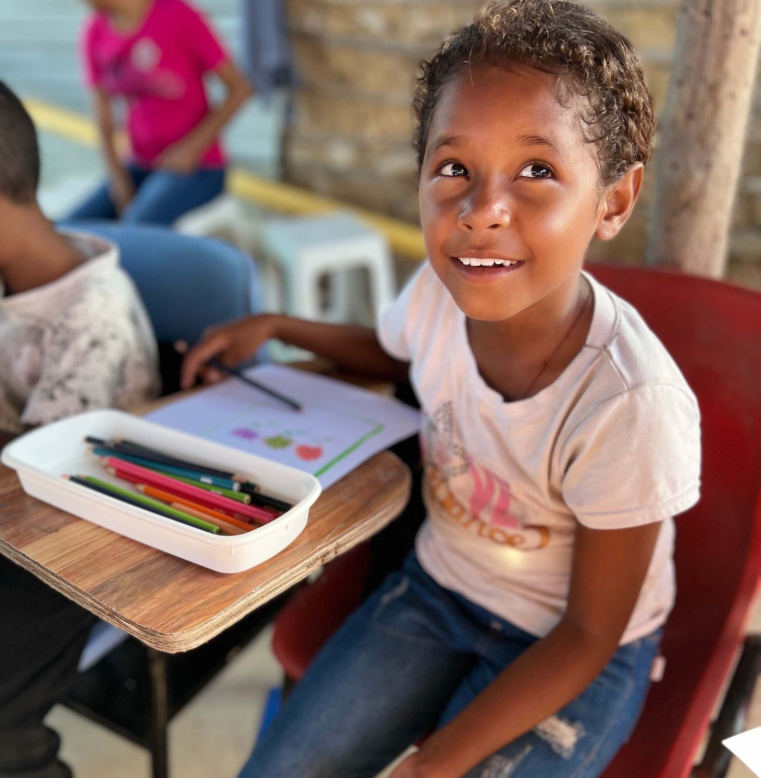 young child smiling at a community school for at-risk children