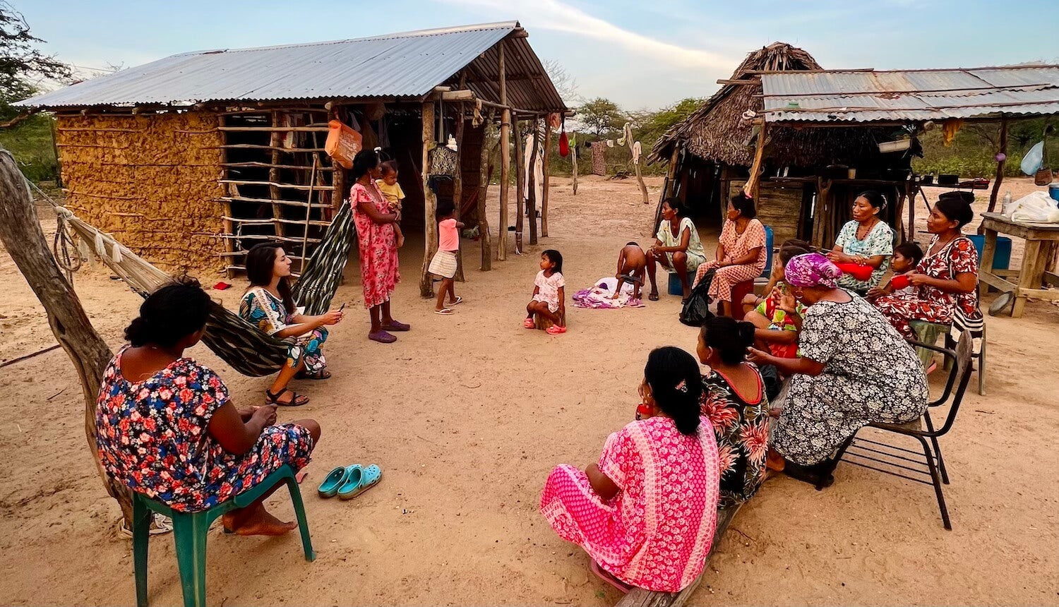 Women sitting in a circle in a traditional Wayuu village