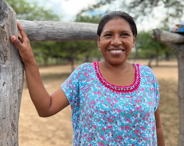 Wayuu woman smiling in a bright "manta" dress in a rural village