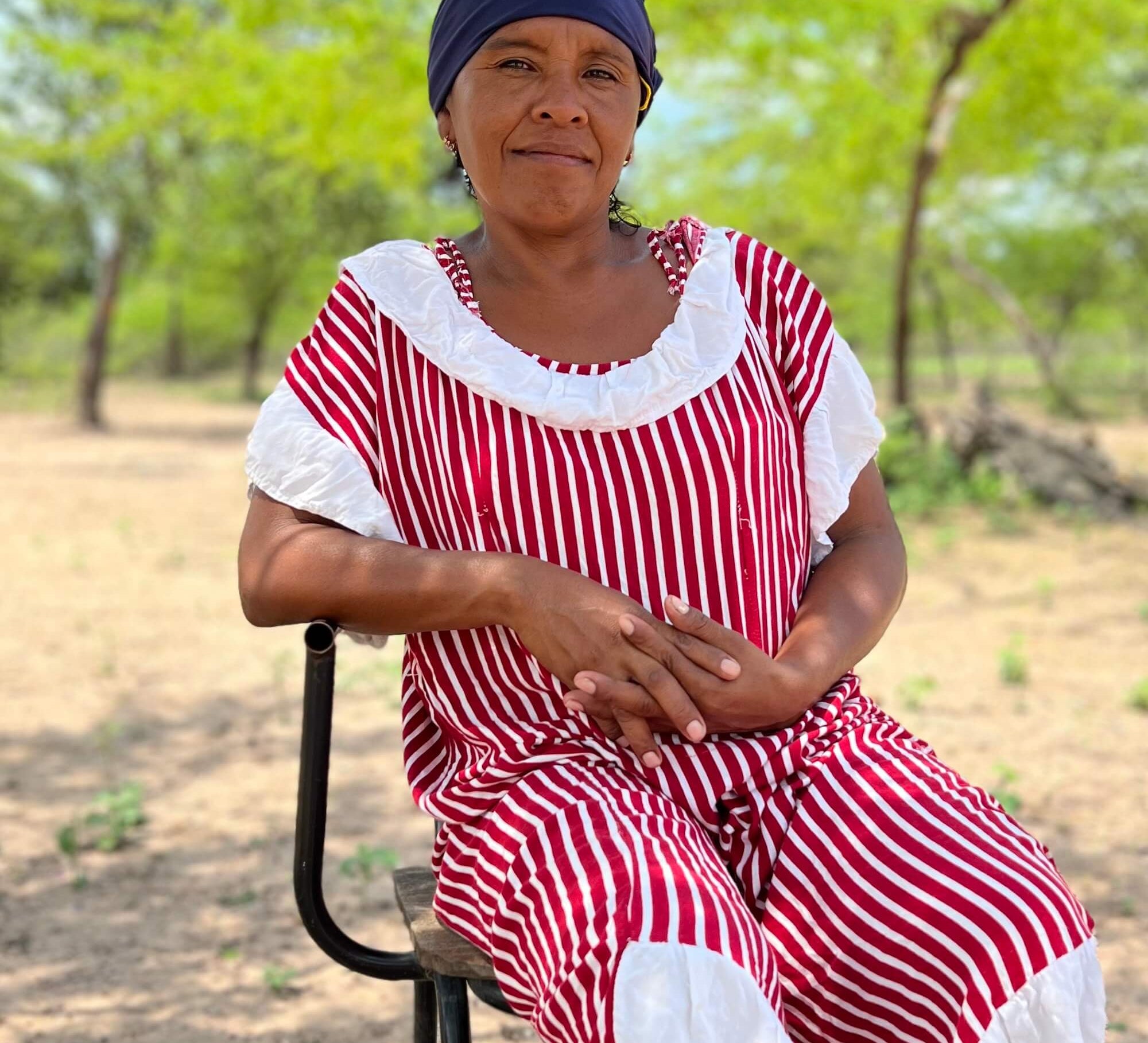 Wayuu woman in red and white "manta" dress in a rural village