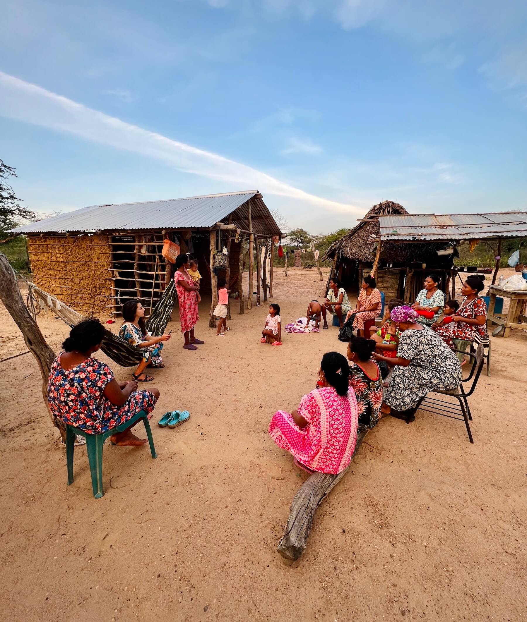 Women sitting in a circle in a traditional Wayuu village