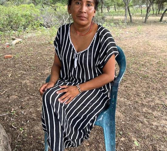 Wayuu women sitting in a chair in an a "manta" dress