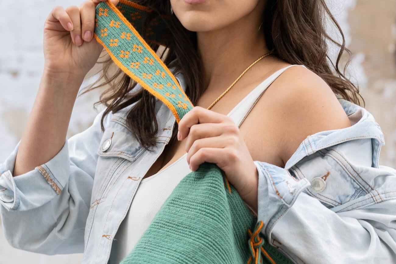 girl posing with a teal green Wayuu crossbody mochila