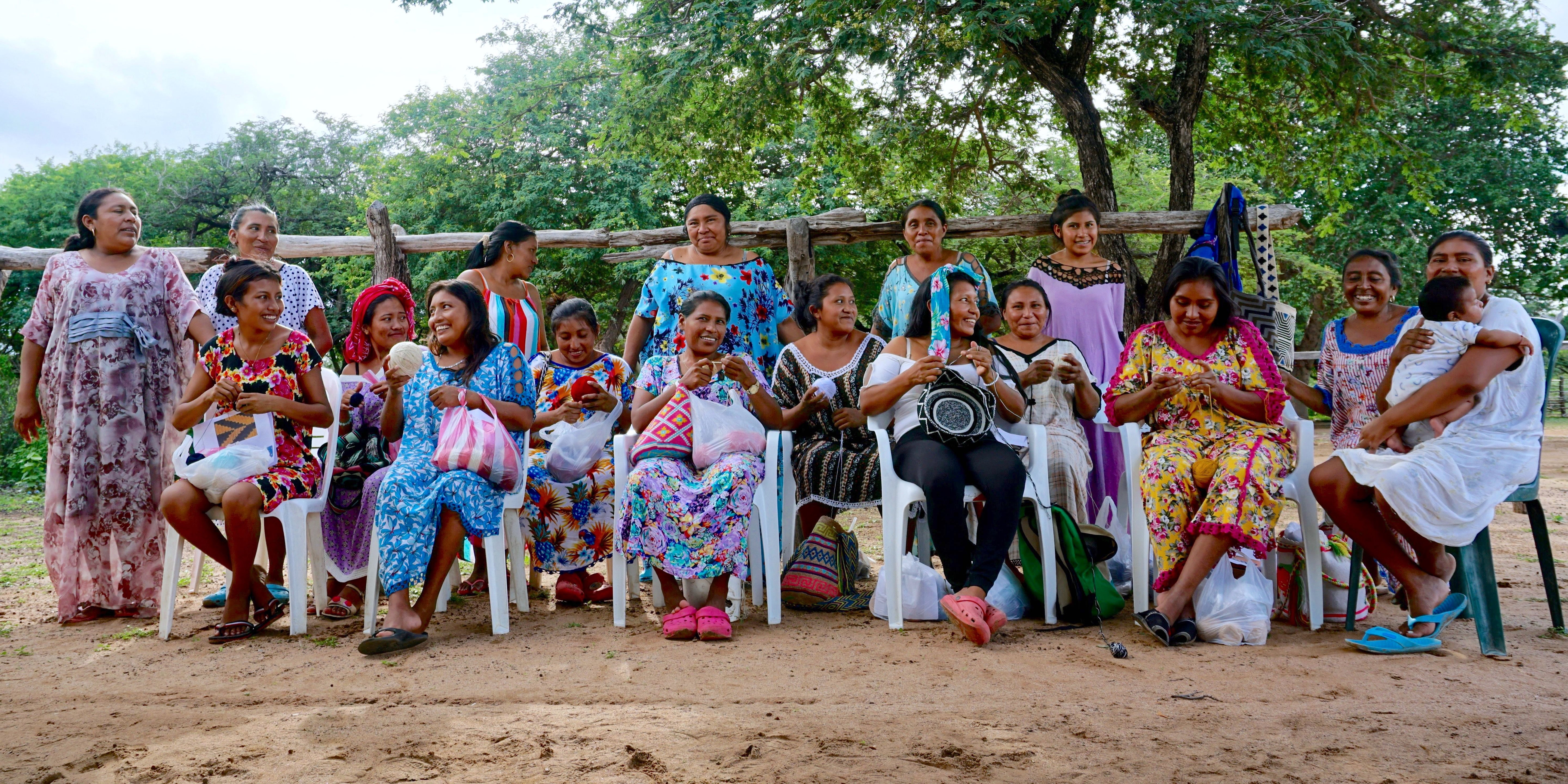 group of Wayuu women smiling and crocheting crossbody mochilas